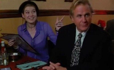 Ellem Pompeo sitting with another man at a diner table