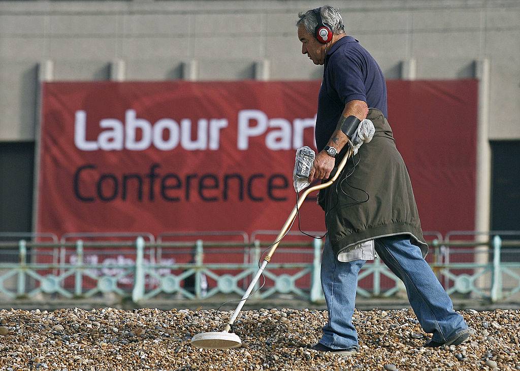 A metal detecting enthusiast searches the beach